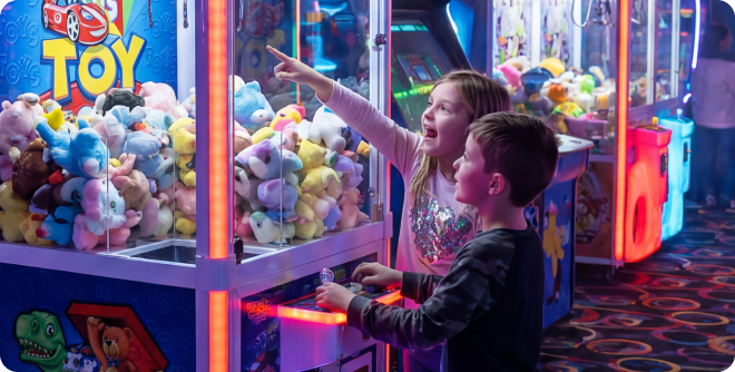 A family playing a plush crane machine